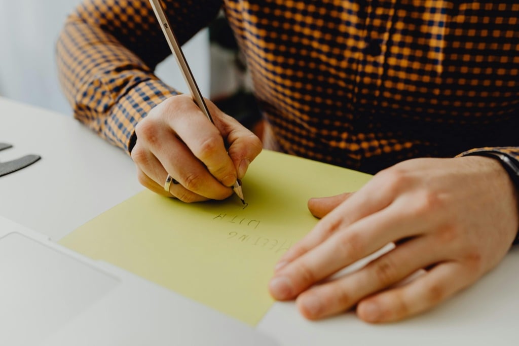 Man met potlood in hand schrijft op b1 niveau