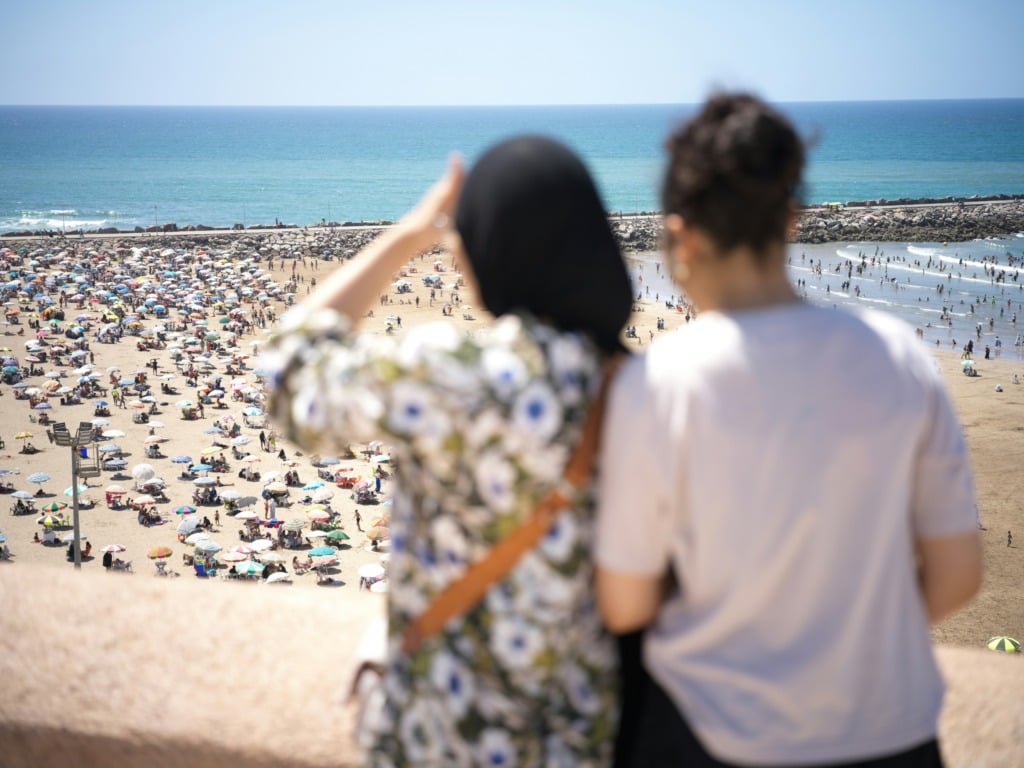 Two women looking at a crowded beach
