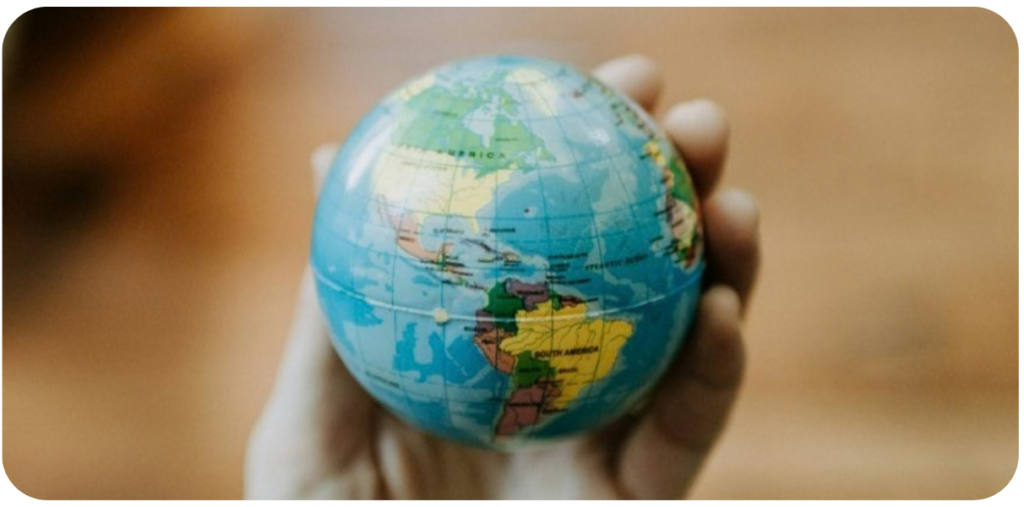 Hand holding a globe, representing consistent content across languages, markets and countries.
